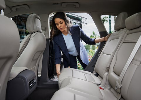 A woman slides the second-row seat forward to create more cargo space | Performance Lincoln Bountiful in Bountiful UT