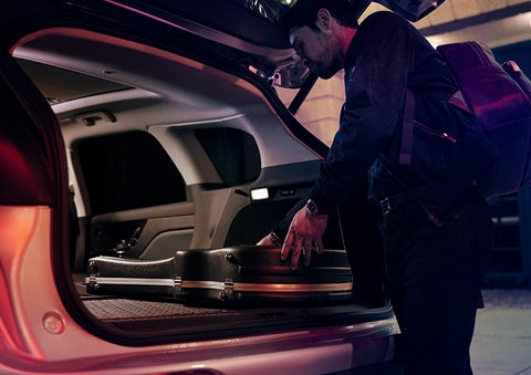 A man is shown loading cargo into the rear of a 2023 Lincoln Corsair® SUV with the second-row seats folded flat. | Performance Lincoln Bountiful in Bountiful UT