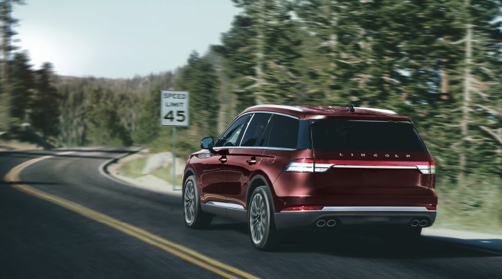 A 2024 Lincoln Aviator® SUV is being driven on a winding mountain road | Performance Lincoln Bountiful in Bountiful UT