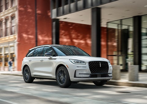 The 2024 Lincoln Corsair® SUV with the Jet Appearance Package and a Pristine White exterior is parked on a city street. | Performance Lincoln Bountiful in Bountiful UT