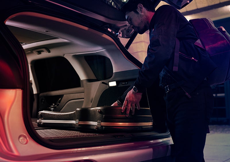 A man is shown loading cargo into the rear of a 2024 Lincoln Corsair® SUV with the second-row seats folded flat. | Performance Lincoln Bountiful in Bountiful UT